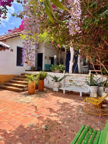 a patio with a white bench and trees and flowers at Casa Bakero in Barichara
