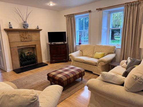 a living room with two couches and a fireplace at 19th century 5-bedroom villa with free private parking in Elgin