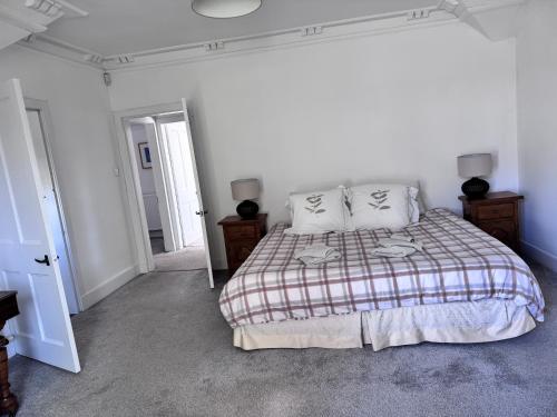 a bedroom with a bed with a plaid blanket at 19th century 5-bedroom villa with free private parking in Elgin