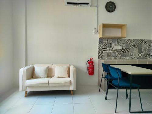 a living room with a white couch and a table and chairs at IFS SoHo 2 Basic Studio in Seri Iskandar