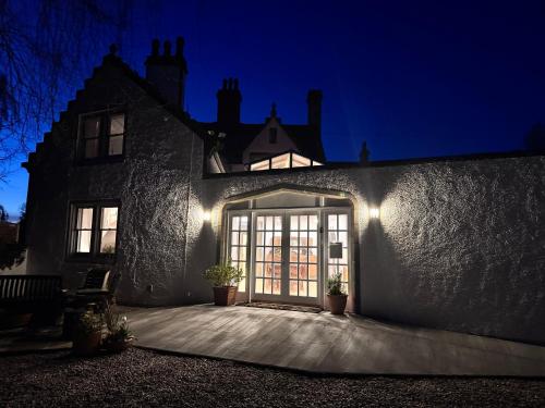 a building with a large glass door at night at 19th century 5-bedroom villa with free private parking in Elgin
