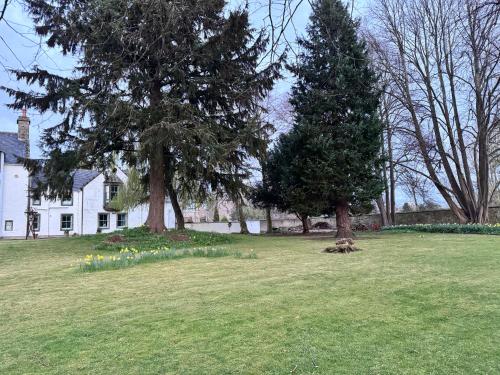 a house with two trees and flowers in a yard at 19th century 5-bedroom villa with free private parking in Elgin