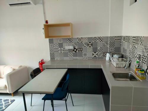 a kitchen with a counter and a sink and a table at IFS SoHo 2 Basic Studio in Seri Iskandar