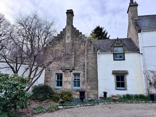 an old stone house with a chimney on top of it at 19th century 5-bedroom villa with free private parking in Elgin