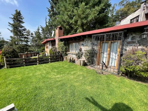 an old stone house with a yard in front of it at Swiss Cabin in Popo Park near Popocatépetl in Ozumba de Alzate