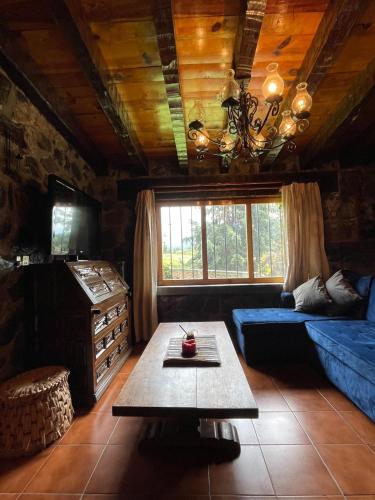 a living room with a blue couch and a table at Swiss Cabin in Popo Park near Popocatépetl in Ozumba de Alzate