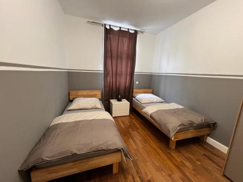two twin beds in a room with wooden floors at Schöne 3 Zimmer Wohnung in Top Lage Heidelberg 1 OG in Heidelberg