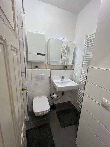 a white bathroom with a sink and a toilet at Schöne 3 Zimmer Wohnung in Top Lage Heidelberg 1 OG in Heidelberg