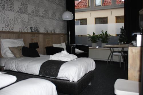 a hotel room with a bed and a table and chairs at Bed & Breakfast Onder de Dekens in Harderwijk