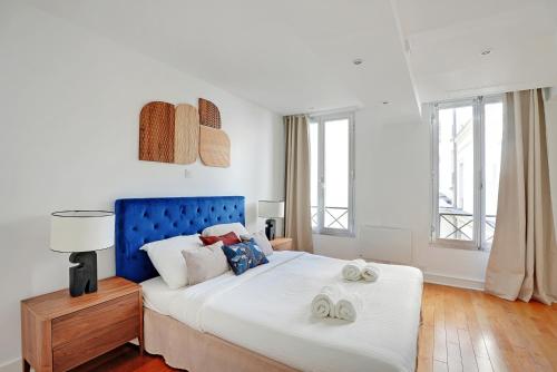 une chambre avec un grand lit avec deux serviettes dessus dans l'établissement Boutique Appartements Madeleine, à Paris