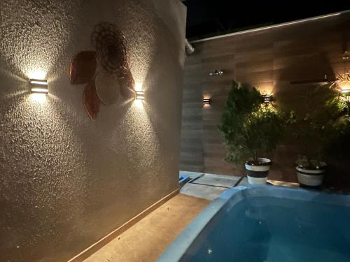 a bath tub in a room with lights on the wall at Aconhego Dourado I Alugue casa com piscina a 17min da praia in Parnaíba