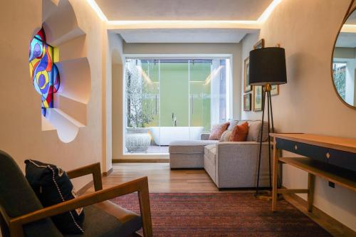 a living room with a couch and a bath tub at Casa Postal Hotel Boutique in Querétaro