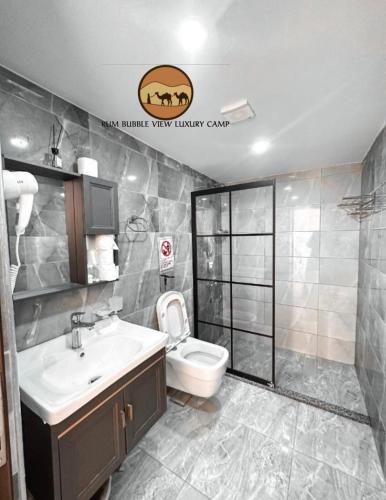 a bathroom with a white toilet and a sink at RUM BUBBLES VIEW lUXURY CAMP in Wadi Rum