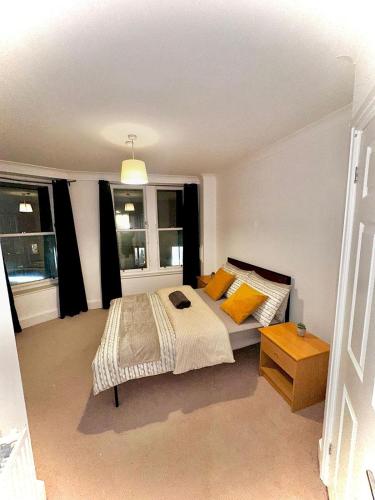a bedroom with a bed and two windows at City LUX Apartment in London