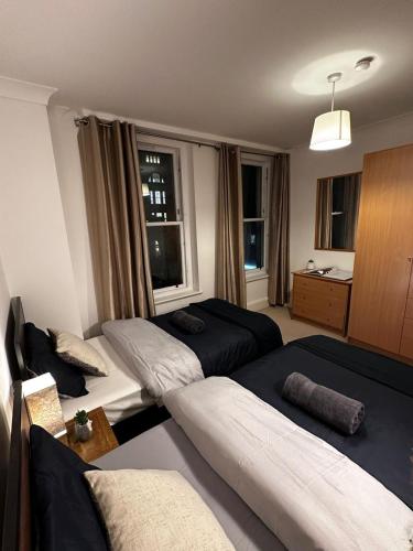 a hotel room with two beds and a window at City LUX Apartment in London