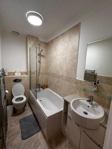 a bathroom with a sink and a tub and a toilet at City LUX Apartment in London