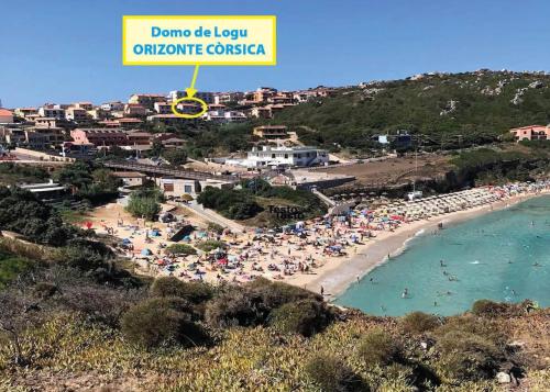 a beach with a lot of people in the water at Domo de Logu ORIZONTE CÒRSICA in Santa Teresa Gallura