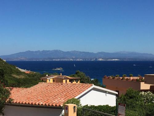 a view of a house with the ocean in the background at Domo de Logu ORIZONTE CÒRSICA in Santa Teresa Gallura