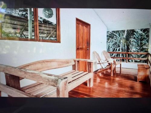 a room with two benches and a table and chairs at Hotel 3 Bamboo Ecolodge in Cahuita