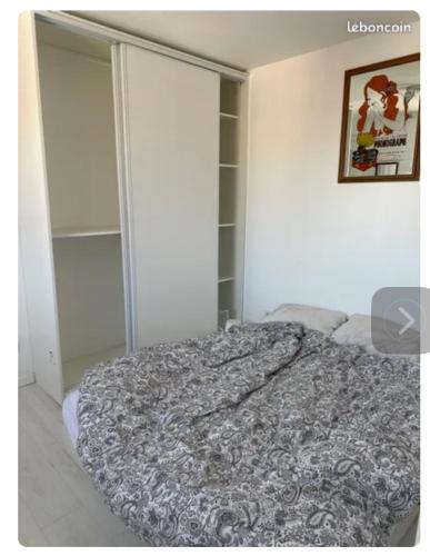 une chambre avec un lit et un tableau au mur dans l'établissement Beau studio lumineux, à Mons-en-Baroeul