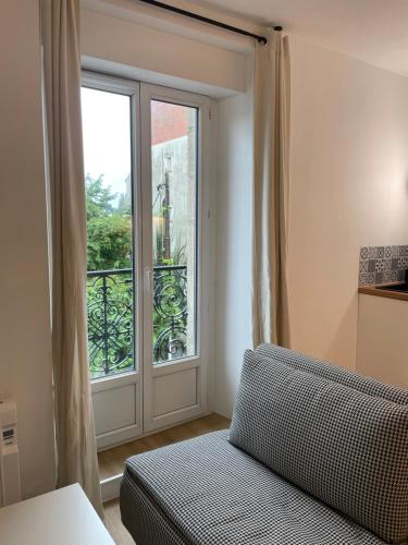 une chambre avec un lit et une grande fenêtre dans l'établissement Studio Cosy Vannes Centre, à Vannes