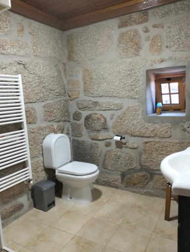 a stone bathroom with a toilet and a sink at Serra da Estrela - Casa Castro in Gouveia