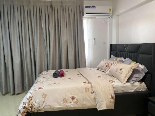 a bed with a white comforter with shoes on it at Adiepena Cozy Apartment- 5mins from KNUST & 7mins from Kumasi Airport in Kumasi
