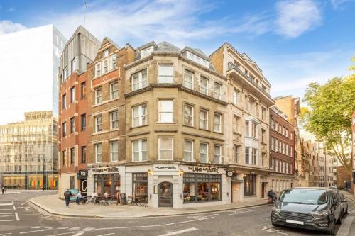 a building on a city street with a car parked in front at City LUX Apartment in London