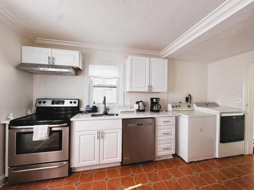 a kitchen with white cabinets and a stove top oven at Entire Family-friendly 4 BR Cozy Unit , Metro walk in Rockville