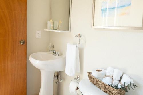 a white bathroom with a sink and a toilet at Departamento amplio con alberca y asador - Hasta 14 personas - B3 in Puerto Vallarta