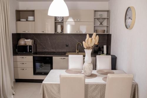 a kitchen with a table with chairs and a vase at Apartments with parking space Banjol, Rab - 5041 in Rab