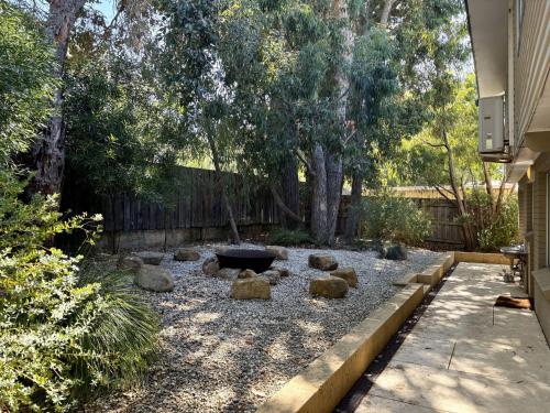 a backyard with a fire pit and some trees at Dunsborough Delight in Dunsborough
