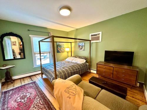 a bedroom with a bed and a couch and a television at The Downtown Downeast Room in Portland