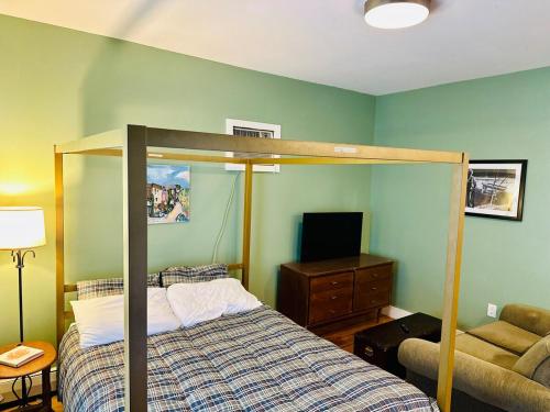 a bedroom with a canopy bed and a television at The Downtown Downeast Room in Portland
