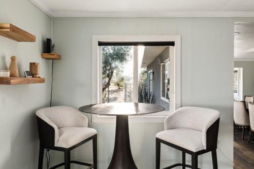a dining room with a table and two chairs at Sunset Grove By The Cohost Company in Yucca Valley
