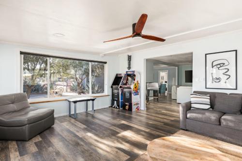 a living room with a couch and a ceiling fan at Sunset Grove By The Cohost Company in Yucca Valley