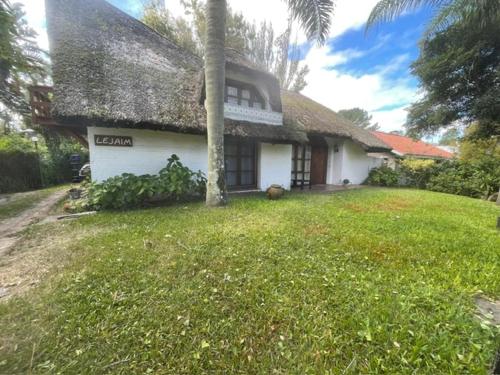 ein weißes Haus mit einem Strohdach und einem Hof in der Unterkunft Casa a 2 cuadras mar Hasta 14 personas in Punta del Este