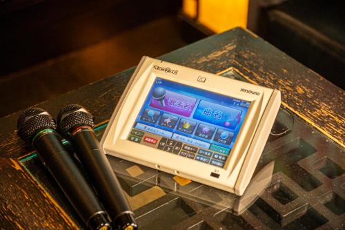 a cell phone sitting on a table with two microphones at Hotel Brio - Adult Only- in Kyoto