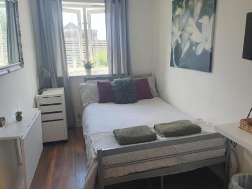 a small bedroom with a bed and a window at Stylish Small Double with Free Parking near Hampton Court-R1 in West Molesey