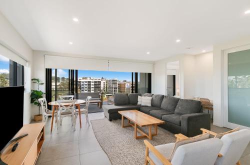 una sala de estar con un sofá y una mesa en The Ivory 20, en Tweed Heads
