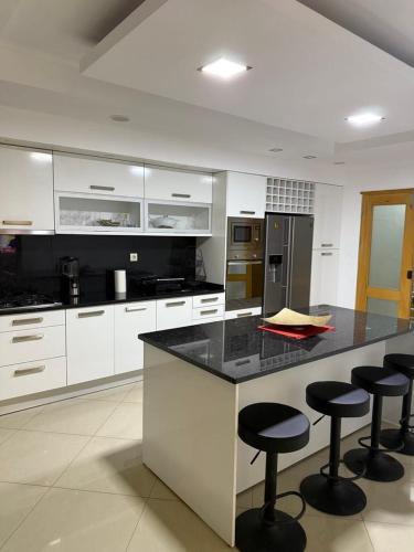 a kitchen with white cabinets and black counter tops at Casa Cucuia in Praia