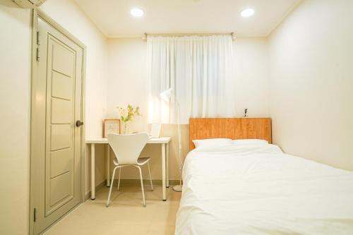 a bedroom with a bed and a desk with a chair at Sol Stay in Seoul