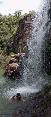 a person in the water next to a waterfall at Pueblo Nómade in Tranqueras