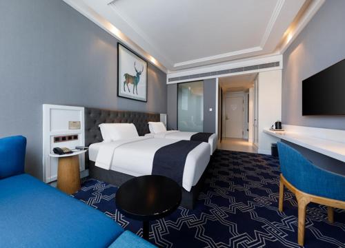 a hotel room with a large bed and a couch at Jinan Xicheng Quanying Hotel in Dangjiazhuang