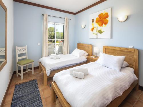 a bedroom with two beds and a window at Charming apartment in Benagil with pool in Benagil