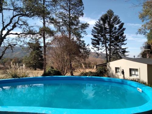 a blue swimming pool in front of a house at Ntra Sra de los Angeles in Salta