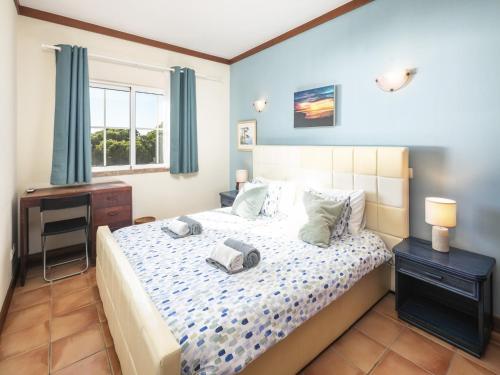 a bedroom with a bed and a desk and a window at Seaside Apartment in Picturesque Benagil in Benagil