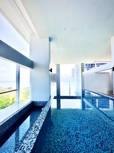 a swimming pool in a building with windows at Sunrise @ Gurney in George Town