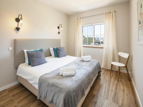 a bedroom with a large bed with towels on it at Modern apartment with sea views, terrace in Benagil