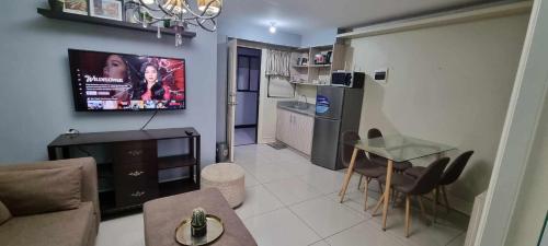 a living room with a couch and a tv on the wall at Elegant 2BR Condo unit with free WiFi in Anabu Primero